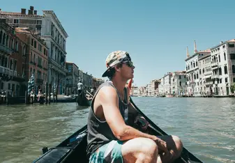 A man sits in a canoe in Venice.