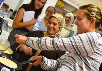 Student cooks baghrir with Darija teacher