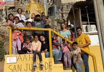 Children and volunteers in group on the stairs near the classroom