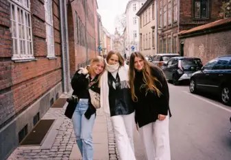 Three students walking through a street