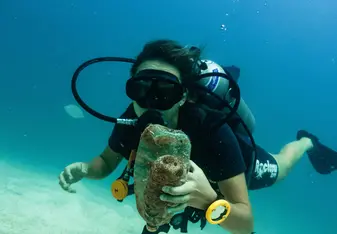 a scuba diver holds trash 