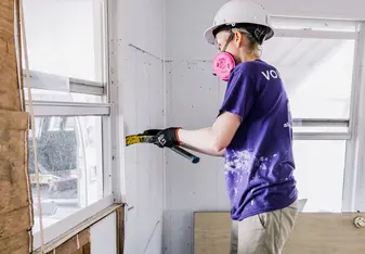 Disaster relief volunteer working inside a home impacted by Hurricane Ian