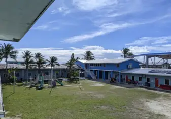 Field with play structure.  Classrooms in the background