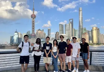 Students posing with Shanghai skyline behind them 
