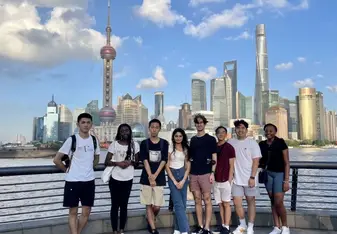 Students posing with Shanghai skyline behind them 