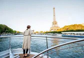 A woman on a boat looks at the Eiffel Tower.