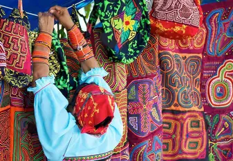 Panamanian woman hanging colorful textiles on a clothes line