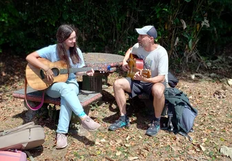 Intern playing guitar with our music teacher