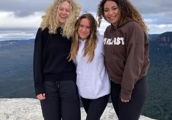 Three students on a mountaintop in Australia