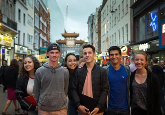 High school students stand on a street.