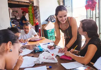 A woman teaches a class of adult students.