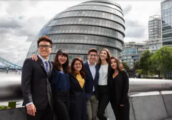 Interns stand together and smile in London.