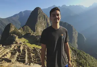 A man stands in front of Machu Picchu.