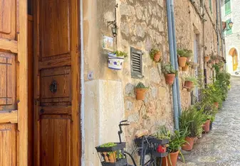 A quaint alleyway featuring a vintage bicycle leaning against a weathered door, capturing the essence of Spain and RVF International’s teach abroad adventure.