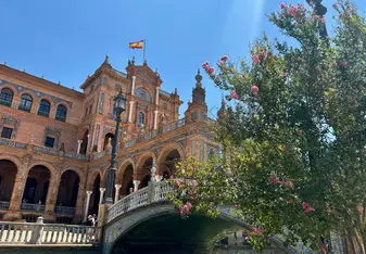 Stunning view of Plaza de España in Seville, Spain, with its historic architecture and Spanish flag waving—immerse yourself in Spain’s culture while teaching English abroad with RVF International.
