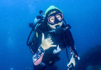Student is scuba diving and giving a thumbs up