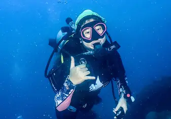 Student is scuba diving and giving a thumbs up