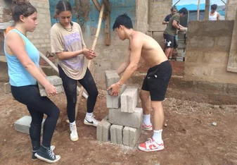 Construction volunteers arrainging bricks