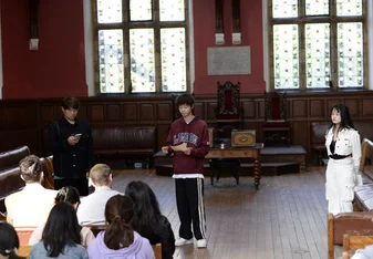 Three students presenting in the Oxford Union