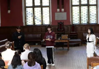 Three students presenting in the Oxford Union