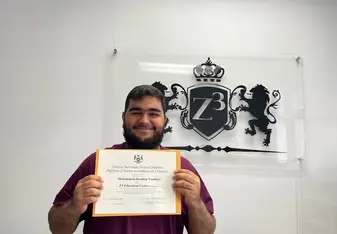 A graduating high school student holding a OSSD diploma from Z3 Education Centre