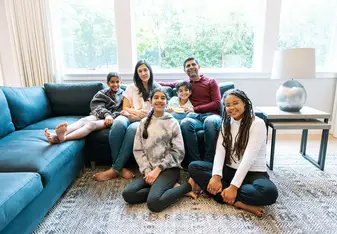 Au pair sitting with host family in the living room