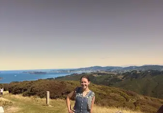 Leah in front of a forested ocean landscape