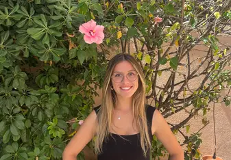 Emma stands in front of flowers