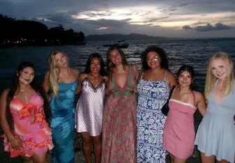 Katie poses with friends in front of ocean