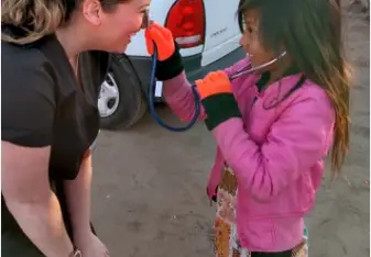 Bethany College Student teaching child how to use stethoscope