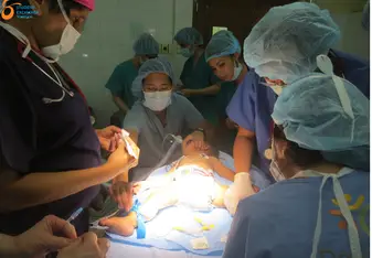 Assisting a group of doctors in a child surgery