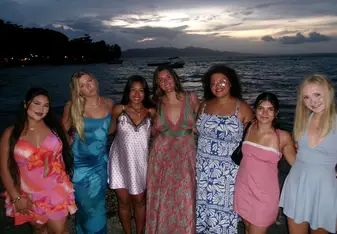 Katie poses with friends in front of ocean