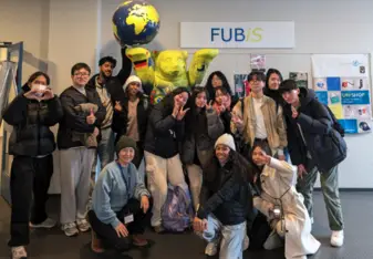 Sophia and students smile band together and hold up balloons celebrating