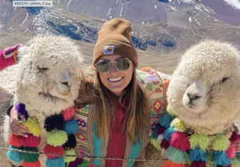 Maggie stands for a photo between two Alpacas 