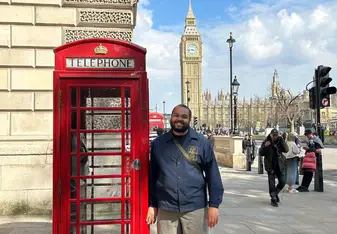 Man standing beside a British red telephone box