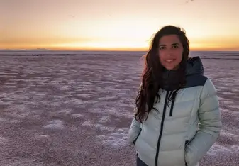 Ilana Gordon from Global Leadership Adventures smiling with a vibrant sunset backdrop behind her