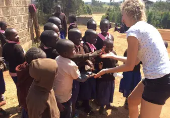Volunteer celebrating with school children 