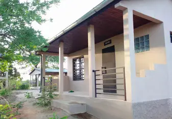 A white stucco porch facing a tamarind tree