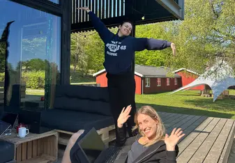 Two interns working outside on bean bags on a porch