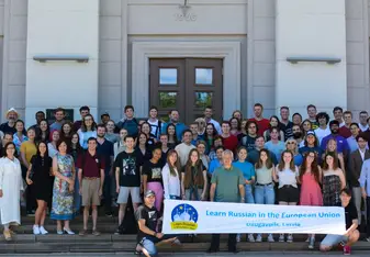 image of smiling students and staff in front of building 