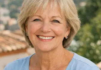 Blonde woman in a blue shirt smiling at the camera