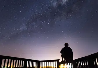 Student poses beneath star filled sky.