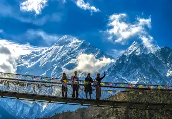 Students pose on bridge in Himalayas.