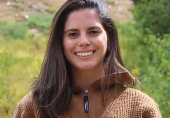 Woman smiling at the camera in the wilderness