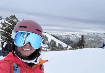 Woman in ski goggles on a snow-covered mountain