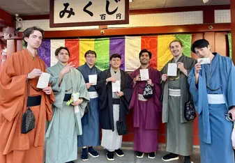 Group of students in kimonos in front of a colorful wall