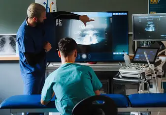 Doctor teaching ultrasound imaging to students during a hands-on clinical skills summer programme in Liverpool