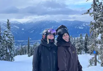 Two people smiling on a snowy mountain