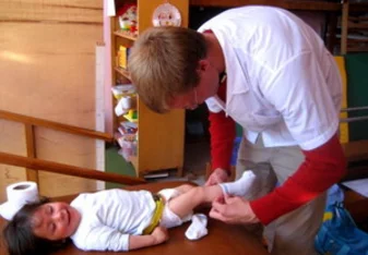 volunteer changing toddler's socks