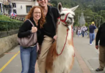 brother and sister riding llamas in colombia